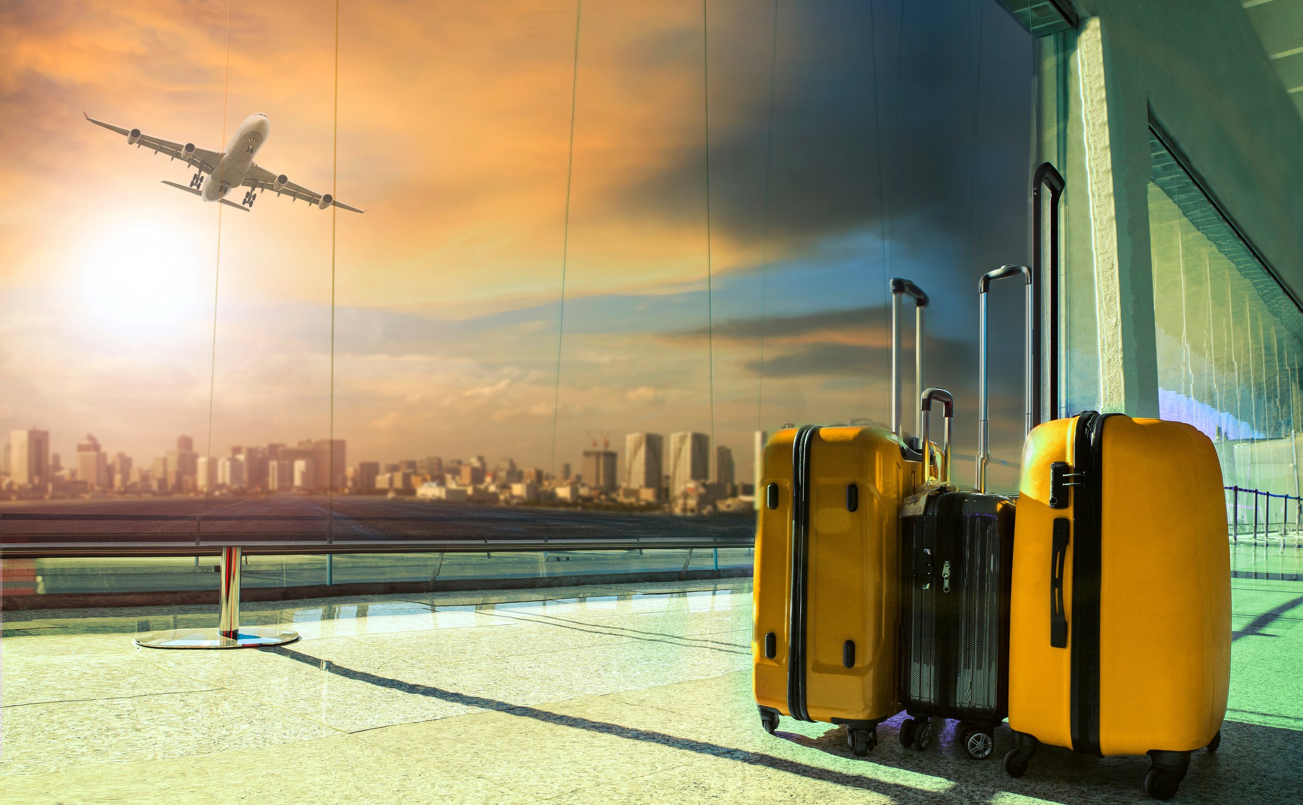 traveling luggage in airport terminal building with passenger plane flying over runway